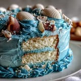 Ocean blue Cancer zodiac cake with edible shells and shimmer.