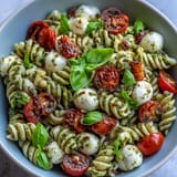 Caprese Pasta Salad: Vibrant tomatoes, creamy mozzarella, and zesty pesto.