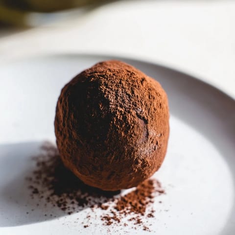 Homemade chocolate truffles, a delicious dessert with a creamy ganache center and festive sprinkles.