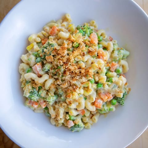 Garden Veg Mac and Cheese served in a white casserole dish, revealing creamy cheddar sauce clinging to elbow noodles and tender vegetables.