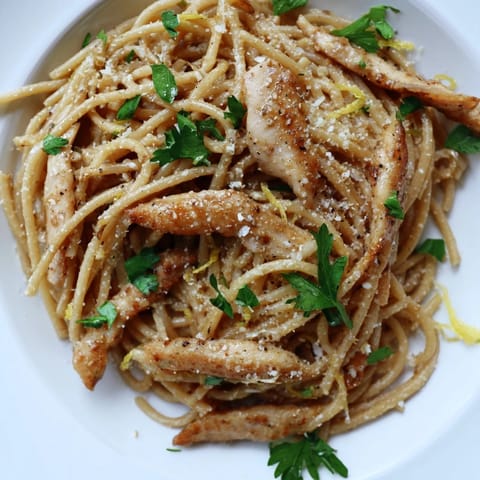 Steaming Brown Butter Lemon Chicken Pasta on a fork, with golden seared chicken and bright lemon zest garnish.