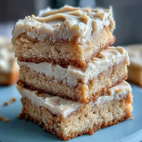 Frosted Almond Flour Sugar Cookie Bars are cut into squares, revealing a soft, chewy interior and sweet topping.