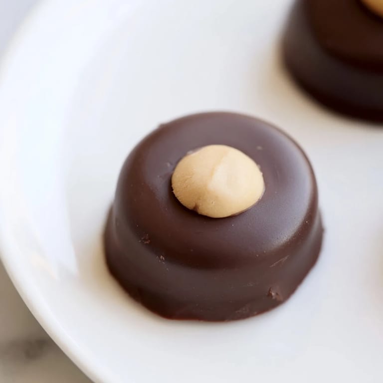 Warm, melted chocolate coats these delightful buckeyes, perfect for holiday gatherings and sharing with friends.