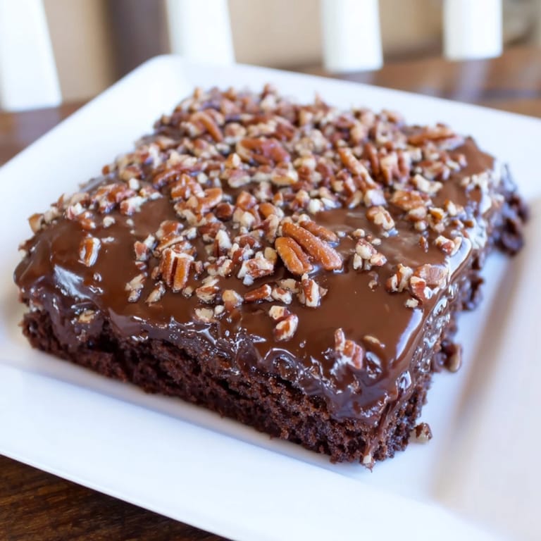 A large, chocolatey Texas sheet cake, still steaming, is covered in a gooey chocolate glaze.